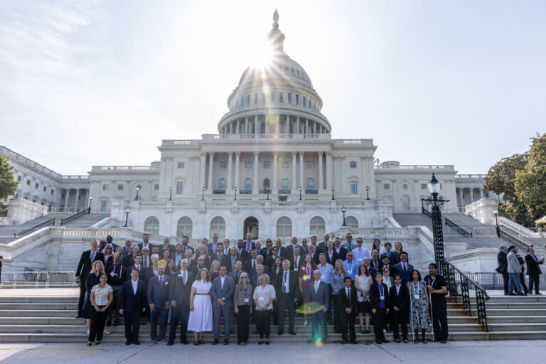 group of 100 people in front of the U.S. Capitol