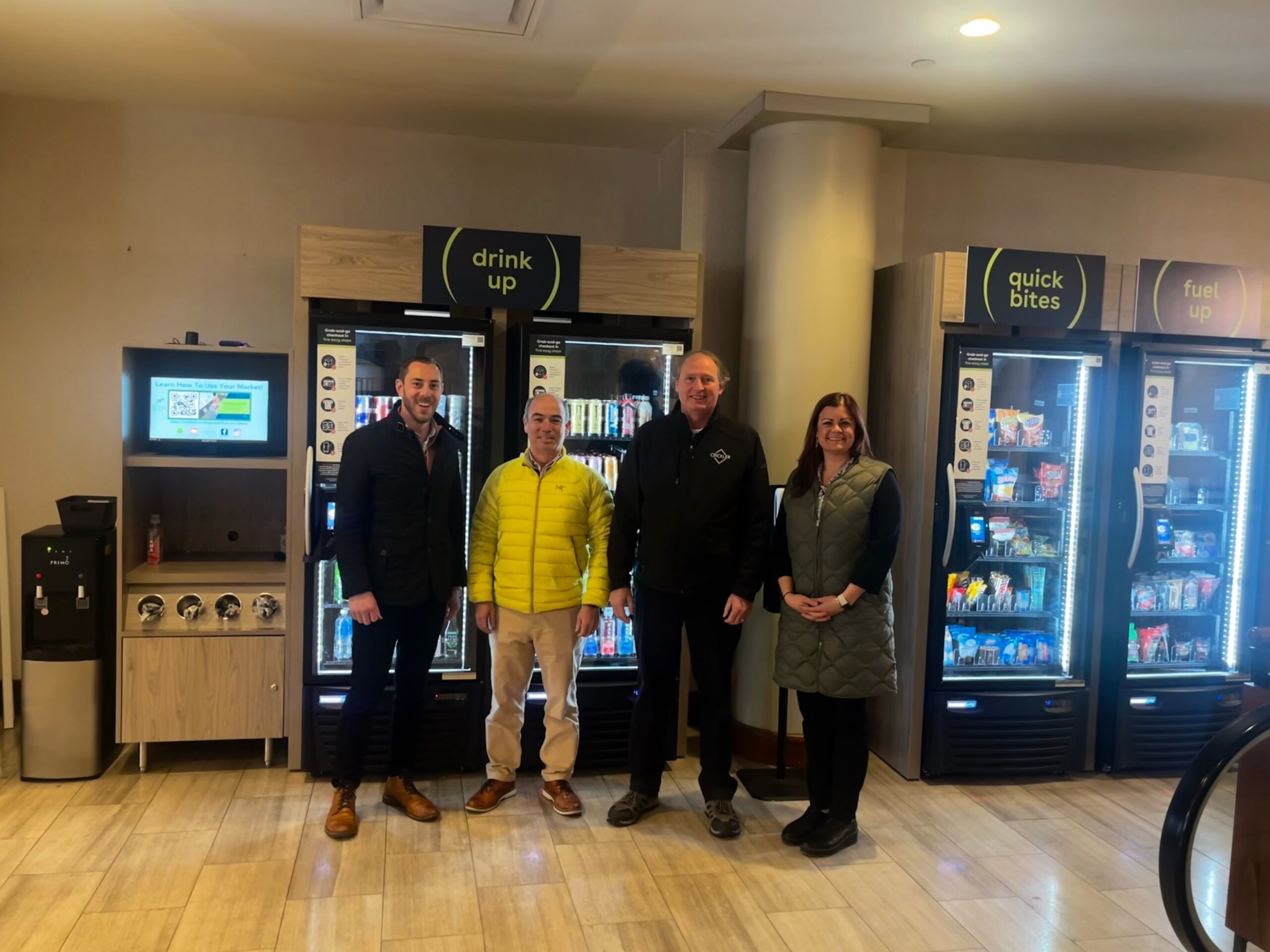 NAMA staff pose for a photo with Crickler Vending staff in front of vending machines.