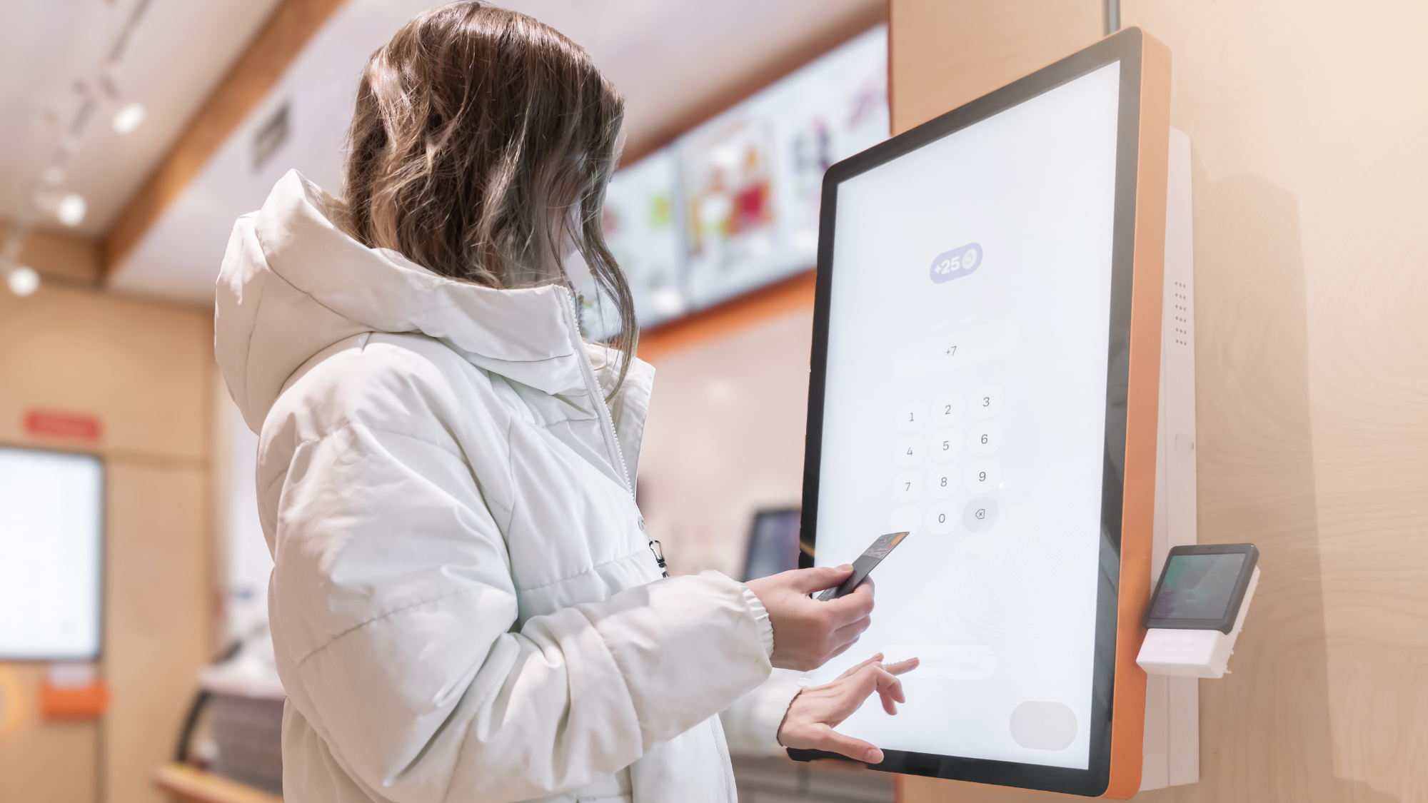 A woman at a kiosk is using it to purchase food.