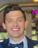 man smiling in formal clothing.