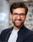 Headshot of a man wearing glasses, smiling.